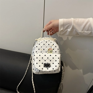 Polka dot backpack with burger embroidery and metal chain strap held by a person