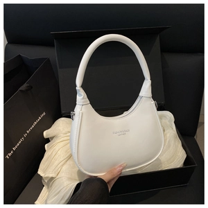 Detailed macro view of white crescent moon bag in a luxury gift box with satin lining