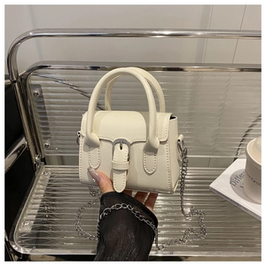 Detail of off-white leather mini flap bag with silver chain strap and metal buckle accent