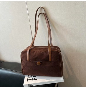 Detail view of large dark brown suede tote bag with front pocket and leather trim