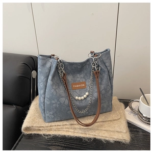 Dettaglio della borsa tote a fiori blu con catena e accenti di perle bianche eleganti