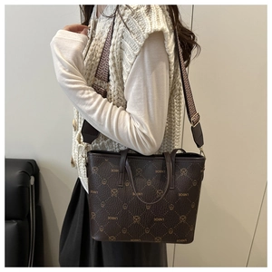 Detail of dark brown tote bag featuring LNBOE cartoon pattern and wide geometric strap