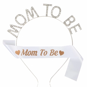 Detail of Mom To Be party set including a crystal headband and white satin shoulder sash