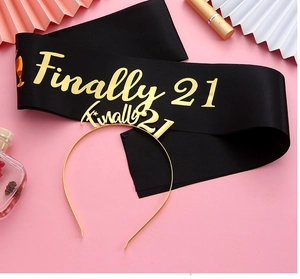 Vue à plat de l'écharpe noire 21e anniversaire et du diadème doré avec texte Finally 21