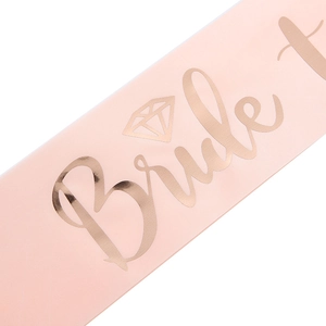 Macro detail of baby pink satin sash with rose gold Bride to be lettering for weddings