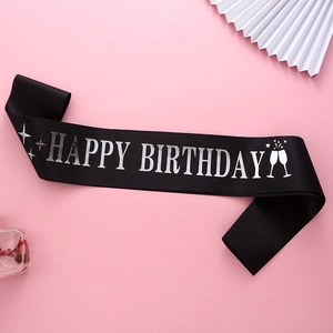 Détail de l'écharpe d'anniversaire en satin noir avec imprimé argenté et verres à champagne