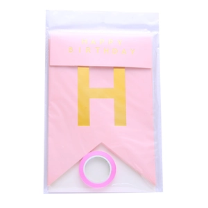 Detail of pink Happy Birthday paper banner with gold lettering in clear packaging with ribbon