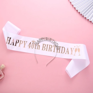 Close-up of 40th birthday set featuring rose gold ribbon and rhinestone tiara on pink background