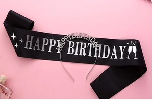 Close-up of a silver rhinestone Happy Birthday headband and black satin sash set