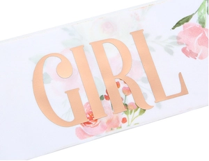 Detail of white party sash with rose gold foil GIRL text and pink floral patterns