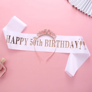 Close-up of white satin 50th birthday sash and rose gold rhinestone tiara set