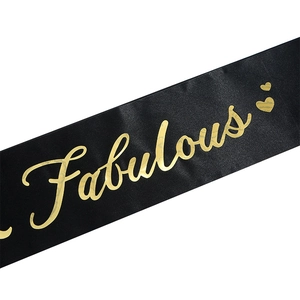 Détail d'une écharpe de fête en satin noir avec lettrage doré Fabulous et cœurs