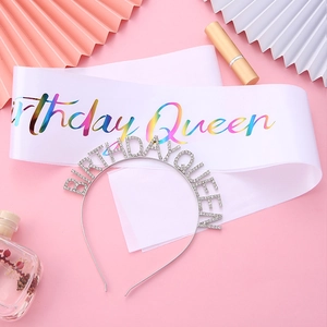 Détail du serre-tête Queen en strass argentés et de l'écharpe en satin blanc sur fond rose