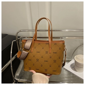 Close-up of brown faux leather bucket bag with LNBOE prints and wide patterned strap