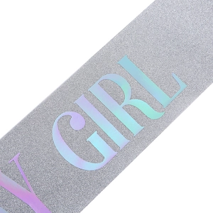 Detail of silver glitter birthday sash with holographic lettering showing the texture