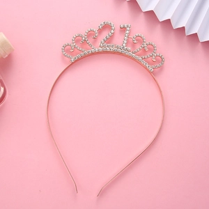 Detail of rose gold 21st birthday crown with sparkling white rhinestones on pink background