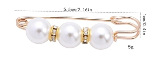 Detailed close-up of golden pearl brooch featuring white faux pearls and clear zircon beads