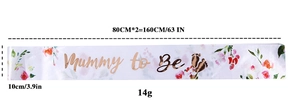 Close-up of Mommy to Be sash with rose gold foil text and pink floral patterns