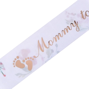 Detail of Mommy to Be sash with rose gold foil lettering and floral satin texture