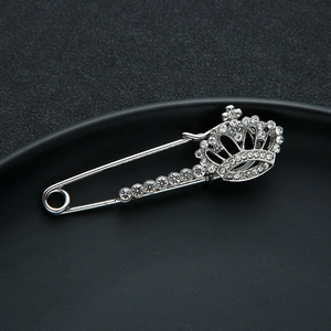 Detailed macro shot of a silver crown brooch with sparkling crystal rhinestones inlay