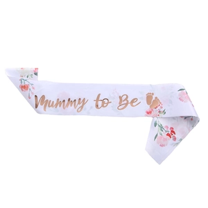 White satin Mummy to Be sash with rose gold lettering and floral patterns for baby shower