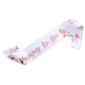 White satin Mummy to Be sash with pink floral patterns and rose gold metallic lettering