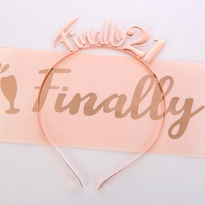 Close-up of rose gold 'Finally 21' metal tiara and pink satin birthday party sash