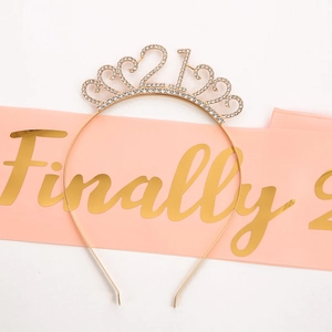 Detailed view of pink Finally 21 satin sash and shimmering gold rhinestone crown set