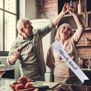Close-up of sparkling white Officially Retired sash worn by an elderly woman dancing