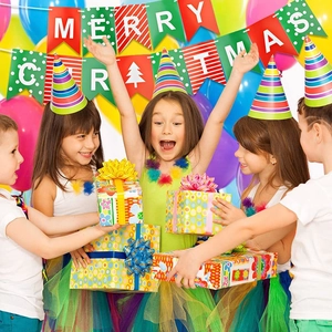 Cheerful children celebrate with Merry Christmas bunting and colorful party hats
