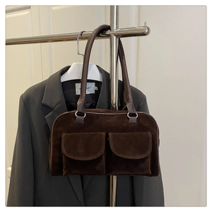 Détail du sac bandoulière en daim marron foncé avec deux poches avant et anneaux argentés