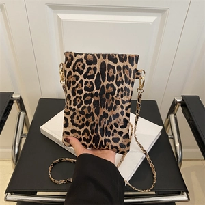 Vintage leopard print crossbody bag with gold chain strap on a minimalist background