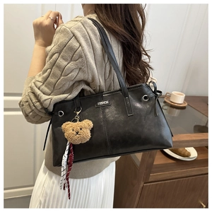 Détail du grand sac cabas noir en cuir synthétique avec charm ours en peluche et logo mode