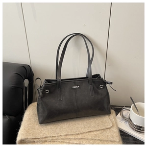 Vue détaillée du sac cabas vintage noir avec étiquette mode et cordons latéraux