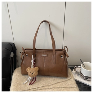 Détail du sac cabas marron en similicuir avec surpiqûres et charm ours en peluche