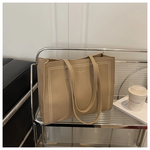 Dettaglio della borsa tote kaki con trama a grana e cuciture decorative bianche