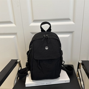 Sac à dos en nylon noir léger avec logo M argenté sur fond minimaliste moderne