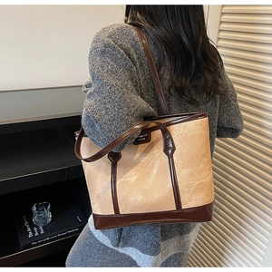 Detail shot of a canvas tote bag with leather straps on model in a modern room