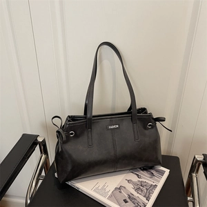 Sac fourre-tout rétro en cuir noir avec cordons de serrage sur une chaise en métal