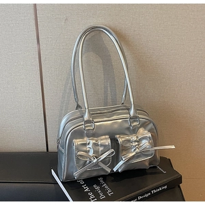 Close-up of metallic silver handbag with stylish bow knots and high gloss finish