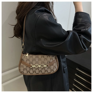 Dettaglio della borsa monogramma marrone con catena dorata a cuore e tracolla in pelle fine