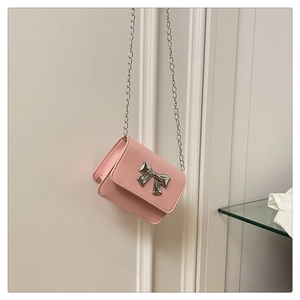Detailed view of pink crossbody bag with silver butterfly clasp and metal chain strap