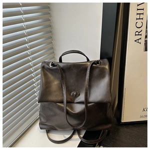 Detail of vintage dark brown backpack with metallic twist-lock and retro faux leather