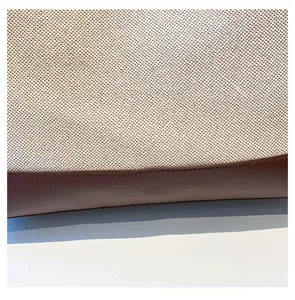 Dettaglio delle cuciture in tela crema e pelle marrone sulla grande borsa tote