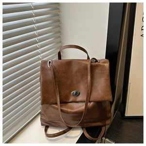 Detail of vintage brown oil wax leather backpack with silver rotating metal lock and flap