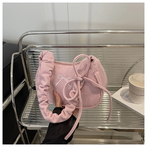 Détail du sac en velours côtelé rose avec broderie nœud et poignée plissée
