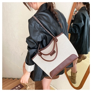 Dettaglio della borsa tote grande con patchwork in tela e tracolle a catena intrecciata