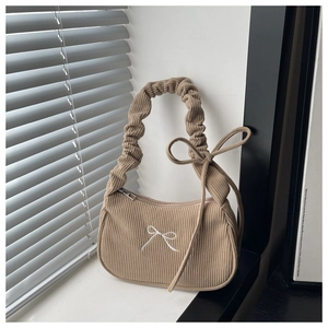 Détail du sac bandoulière en velours côtelé avec nœud brodé blanc et poignée plissée