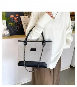 Vista dettagliata della borsa tote in tessuto tweed grigio e finiture in pelle nera