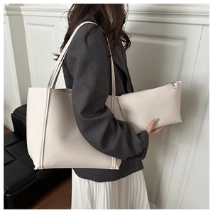 Lifestyle shot of woman with cream tote bag set and small zipper pouch in minimalist style